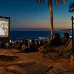cinema plein air cote d azur : écran extérieur au crépuscule, public et mer